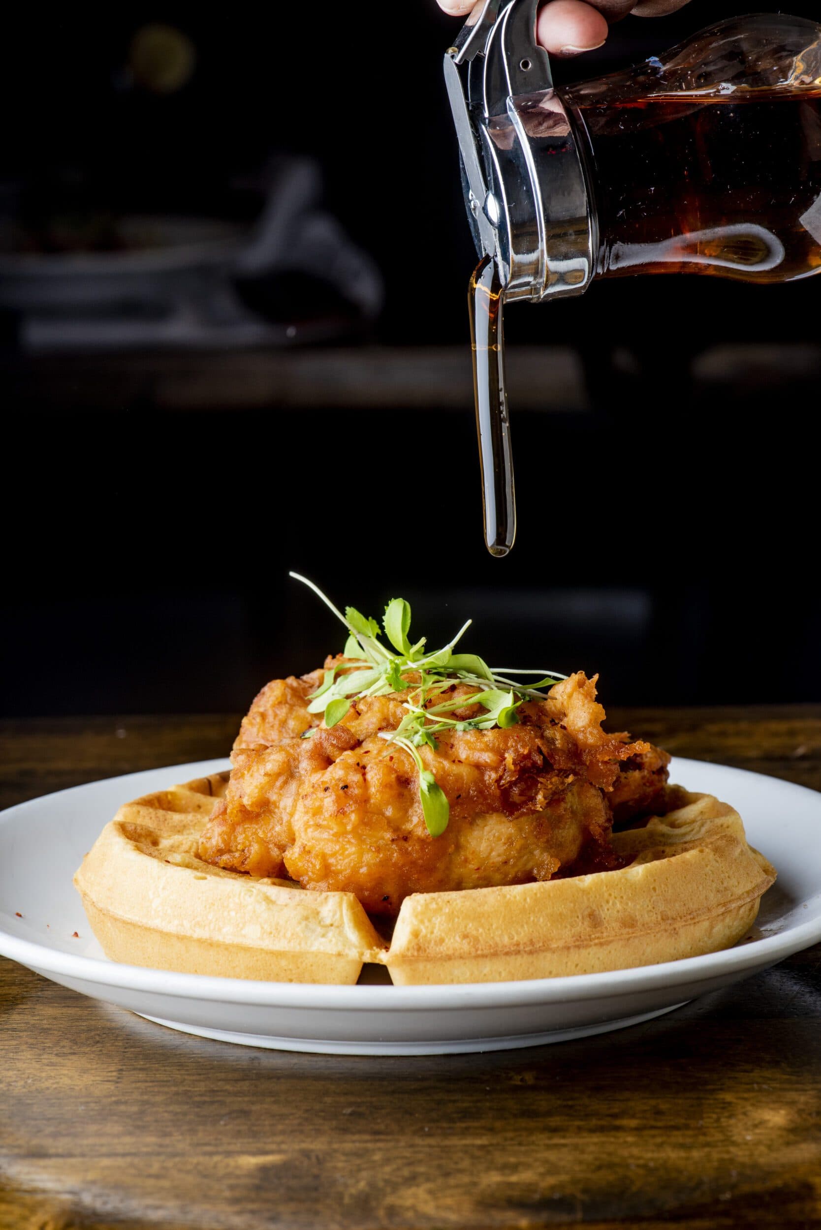 Chicken and waffles. Homemade waffles with crispy southern fried chicken, butter and maple syrup. Classic American breakfast or brunch favorite. Made from scratch waffles served with butter and maple syrup.