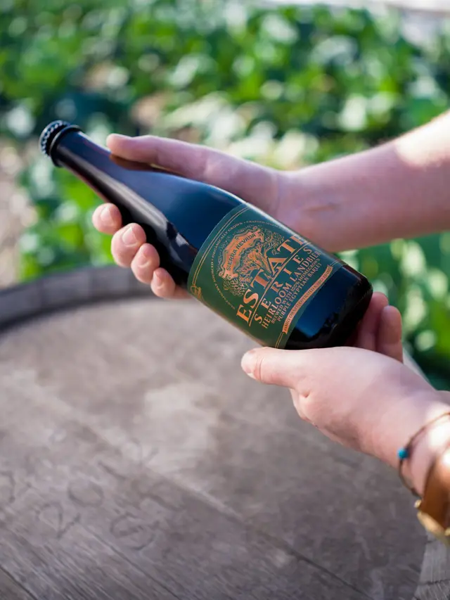 Estate Landbier bottle held by someone outside